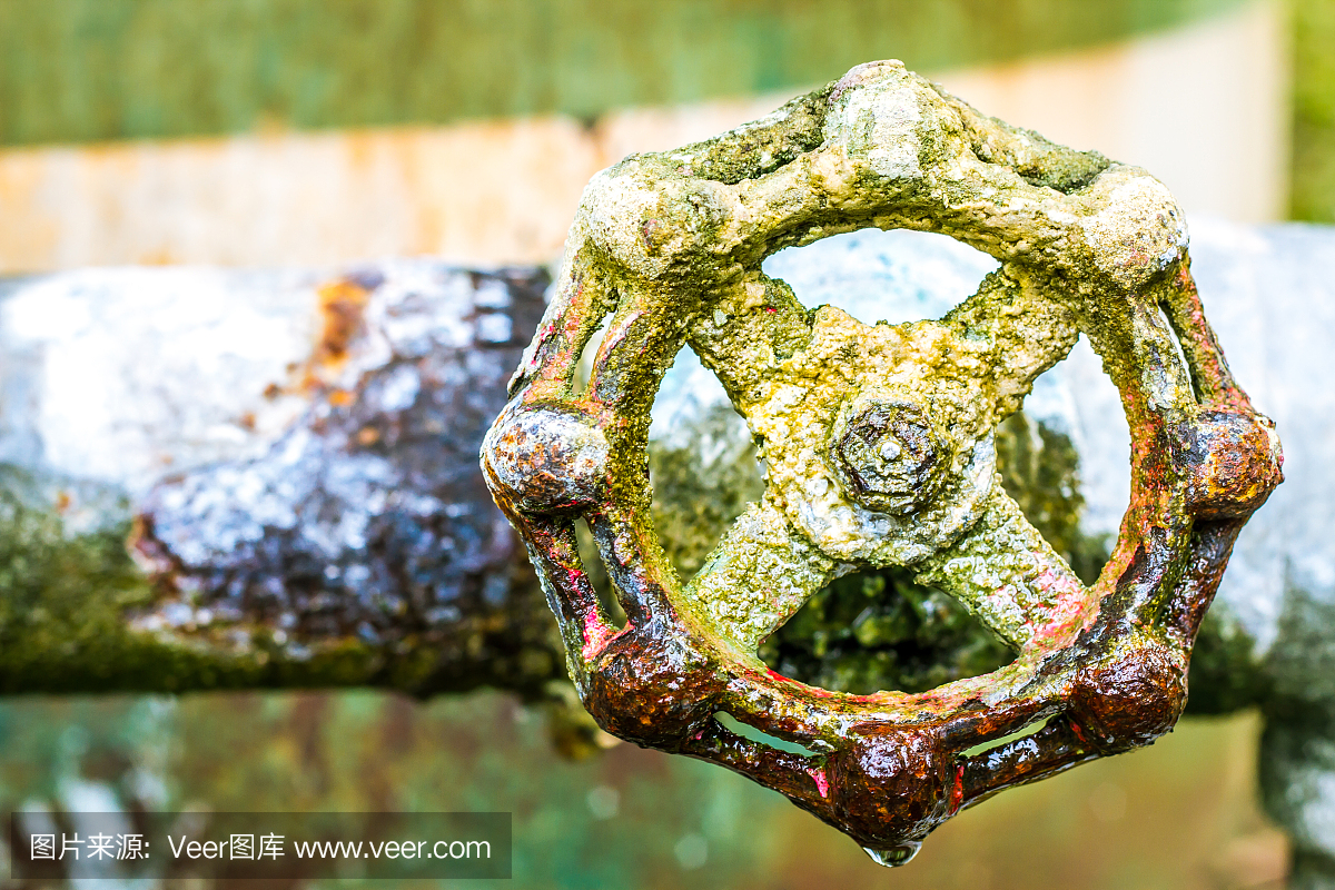 一个生锈的阀门的特写,连接到供水与金属管道,工业金属水标签,看到在一个花园